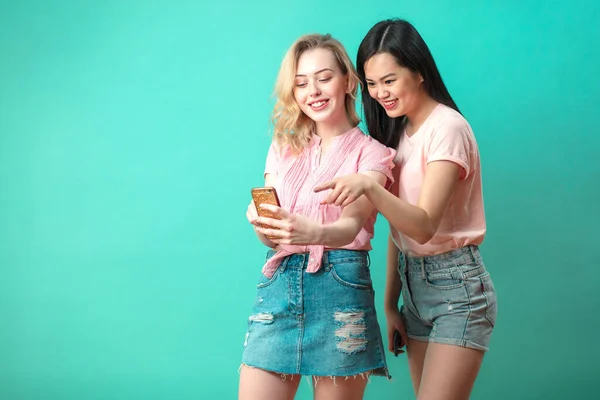 Duas mulheres bonitas multiétnicas asiático e caucasiano tomando selfie no estúdio — Fotografia de Stock
