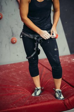 Bir kadına tırmanma ekipmanı yakın.