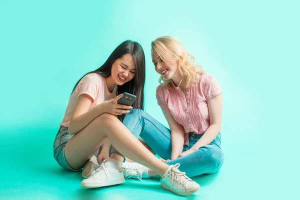 Portret van een twee vrolijke vrouwen die een selfie nemen terwijl ze op de vloer zitten — Stockfoto