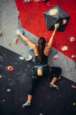 Güzel genç bir kadın yapay bir duvara doğru büyük bir adım atıyor.