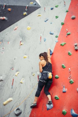 Güzel genç bir kadın yapay bir duvara doğru büyük bir adım atıyor.