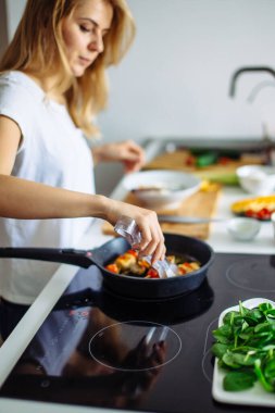 Kızartma tavasında kebap kızartan bir kadın.