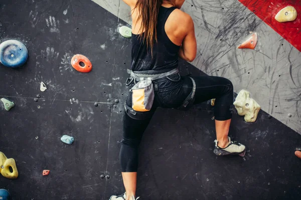 Belle jeune femme faisant un grand pas vers le haut d'un mur artificiel — Photo