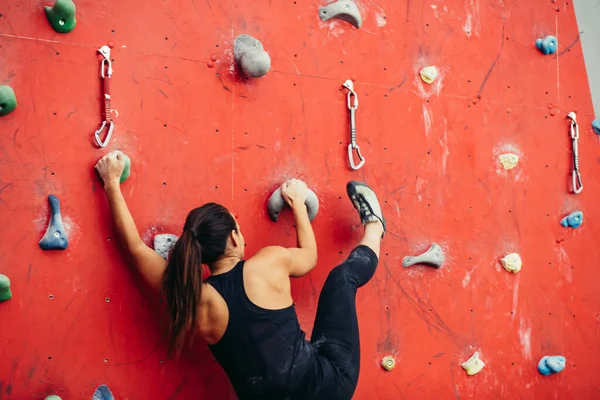 Mulher bonita dando um grande passo acima de uma parede artificial — Fotografia de Stock