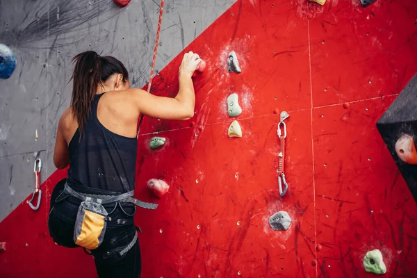 Jeune femme faisant du bloc professionnel dans la salle de gym d'escalade à l'intérieur — Photo