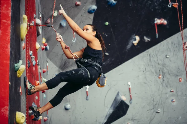 Активна щаслива жінка висить на щільній мотузці в тренувальному центрі скелелазіння — стокове фото