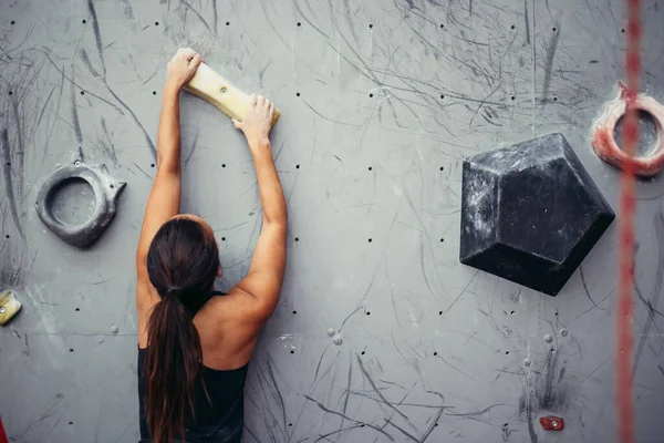 Руки альпиниста держат искусственный камень в тренажерном зале, крупным планом. — стоковое фото