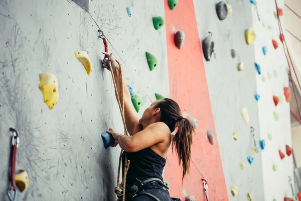 Hermosa joven mujer dando un gran paso por una pared artificial — Foto de Stock