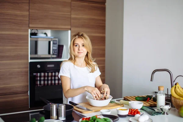 Mujer rubia caucásica cocinando adobo para sabrosos kebabs en la mesa de la cocina —  Fotos de Stock