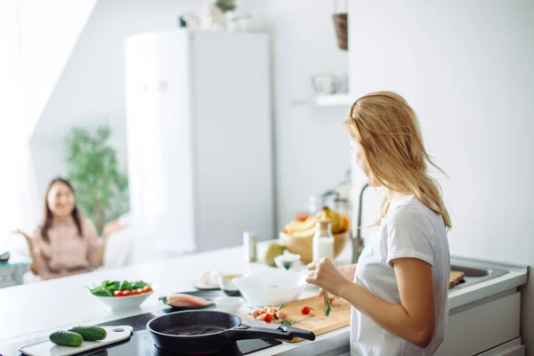 Young housewife making meal for linch in kitchen. rear view — Stock Photo, Image