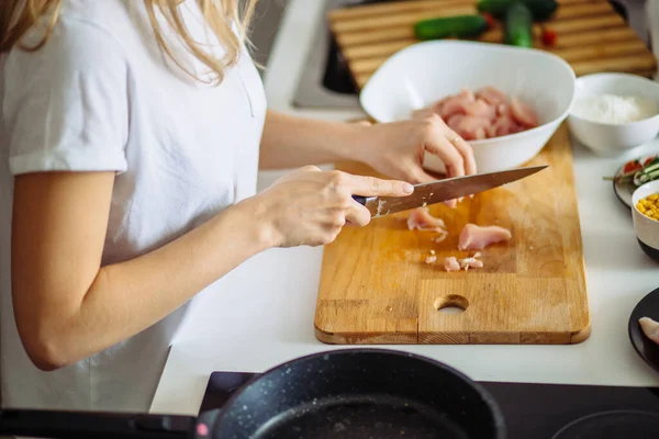 Vista recortada de las manos de la mujer corte de carne de res en la tabla de cortar. — Foto de Stock