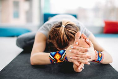 Yogi kızı Janu sirshasana çalışıyor ya da baş-diz öne eğik poz