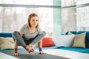 Yoga yapan kadın jimnastik salonunda poz egzersizi yapıyor.