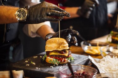 Şef sığır eti, salata ve sebzeli bir burger hazırlar..