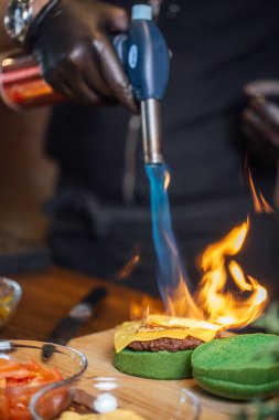 Aşçı hamburgercide biftek yapıyor.