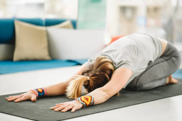 Фитнес-женщина выполняет йогу Поза ребенка на коврик для упражнений в тренажерном зале. — стоковое фото