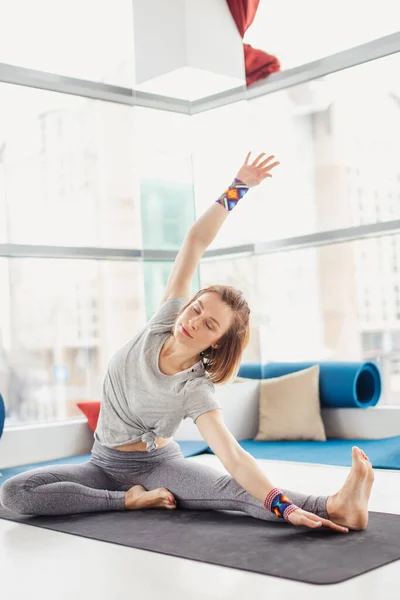 Mujer realizando pose de yoga sobre esterilla, estilo de vida saludable y concepto de fitness — Foto de Stock