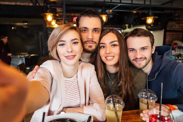 Bir grup gülen arkadaş selfie çekiyor..