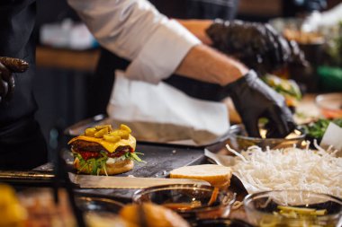 Şef sığır eti, salata ve sebzeli bir burger hazırlar..