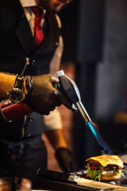 Aşçı hamburgercide biftek yapıyor.