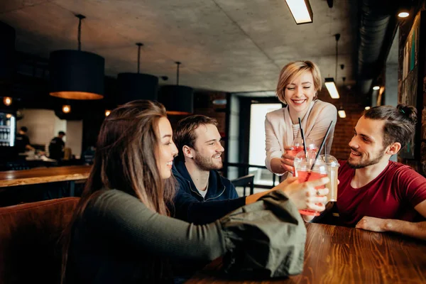 Amigos felices bebiendo bebidas divirtiéndose mientras pasan tiempo juntos en la cafetería — Foto de Stock