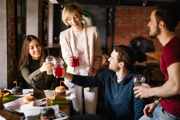 Vänner klamrar ihop glasögon i jubel i baren. — Stockfoto