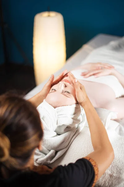 Joven bonita mujer disfrutando de masaje facial procedimiento —  Fotos de Stock