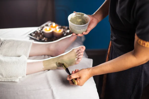 Procedure of applying clay mask on foot by beautician. Mud therapy. — Stock Photo, Image