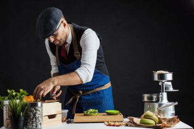 Biftek, salata ve sebzeli yeşil burger pişiren adam..