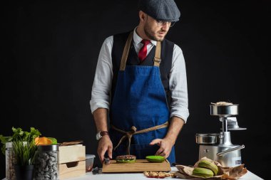 Biftek, salata ve sebzeli yeşil burger pişiren adam..