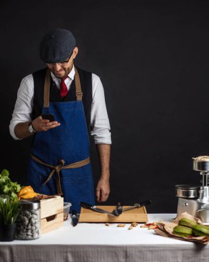 Aşçı lokantanın mutfağında akıllı telefon kullanıyor.