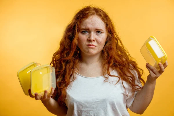 Disgustado hambriento regordeta readwoman sosteniendo vacío almuerzo cajas. — Foto de Stock