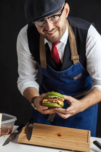 Любитель еды наслаждается готовой самостоятельно приготовить гамбургеры, а затем — стоковое фото