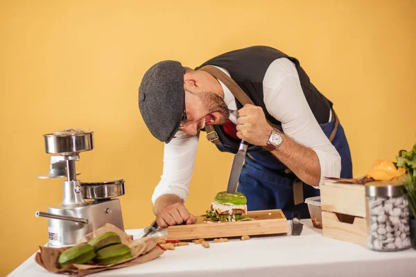 Chef cutting burger into two halfs to perform quality ingredients — Stock Photo, Image