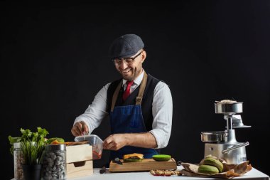 Biftek, salata ve sebzeli yeşil burger pişiren adam..