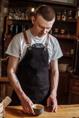 Adam boş bir fincan kahveye bakıyor.