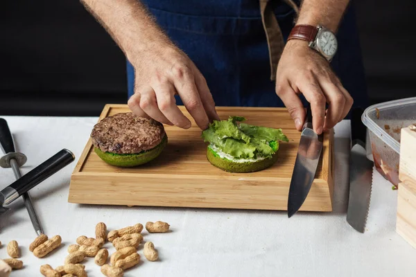 Szef kuchni dodaje bazylii na hamburgera gotowania koncepcji hamburgera — Zdjęcie stockowe