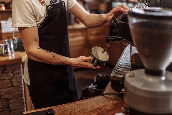 A professional barista pouring coffee from the coffeemaker — Stock Photo, Image