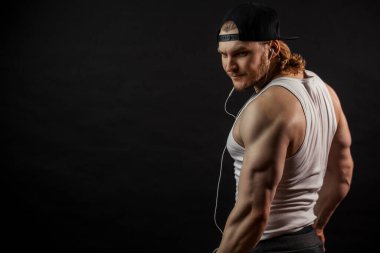 Arkadan çekilen uzun sarı saçlı, güçlü adamın görüntüsü.