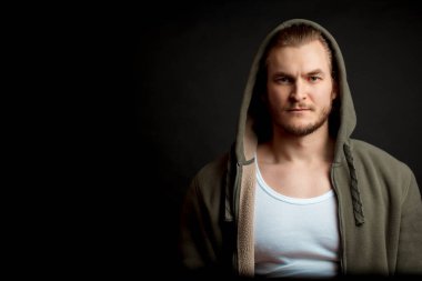 Siyah arka planda izole edilmiş yeşil kazaklı güçlü bir adam. Boşluğu kopyala