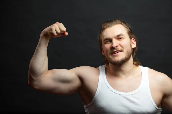 Portret młodego przystojnego brązowłosego mężczyzny ukazującego swoją siłę — Zdjęcie stockowe