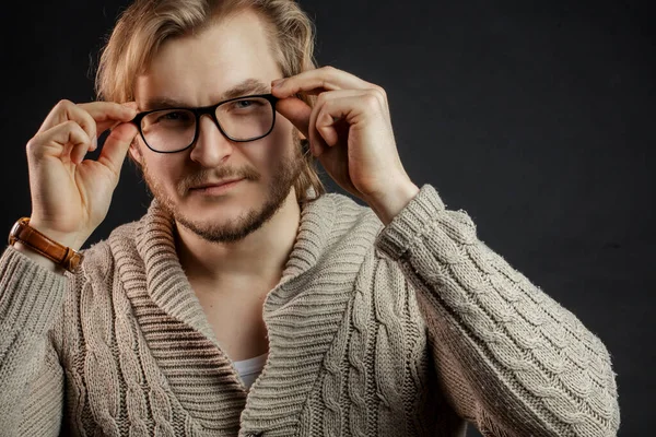 Close up photo of pleasant young male putting on glasses — Stock Photo, Image