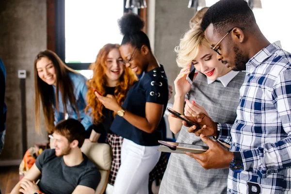 Man is het helpen van jonge mooie vrouw met kort blond haar met haar smartphone — Stockfoto