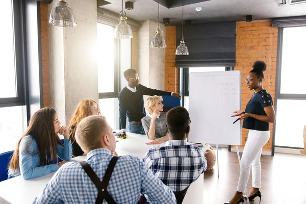 Ausländische Studenten präsentieren Businessplan auf Flipchart — Stockfoto