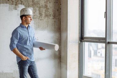 Tasarımlı düşünceli mimar sokağa bakıyor.