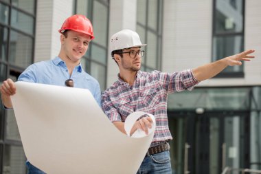 Yakışıklı müteahhit kameraya bakıyor.