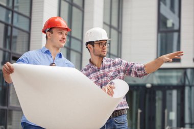 İki inşaatçı inşaatın yapılacağı bölgeyi araştırıyor.