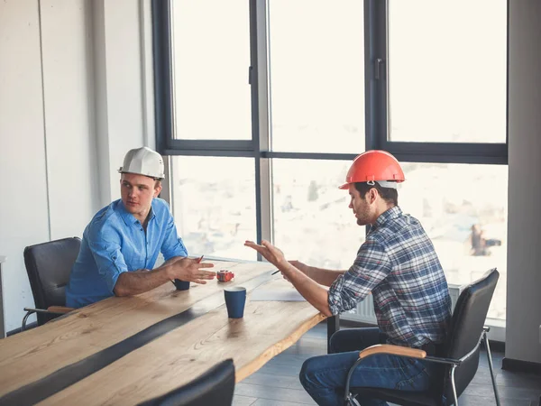 Fleißige Ingenieure sprechen am Tisch über Arbeit — Stockfoto