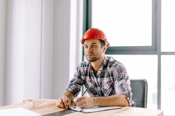 Stilig byggmästare fyller upp nödvändiga dokument — Stockfoto