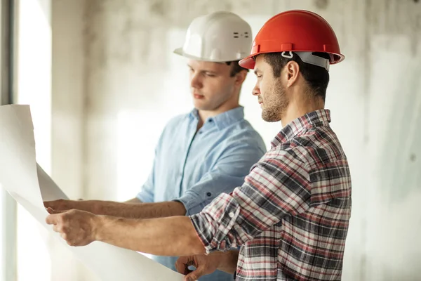 Zwei gut aussehende Bauarbeiter werden ein Haus umbauen . — Stockfoto